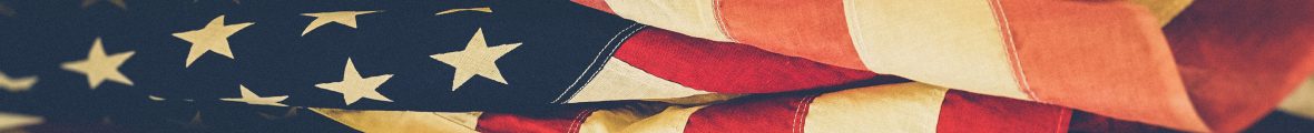 Horizontal banner comprised of an image of an unfurled American flag.